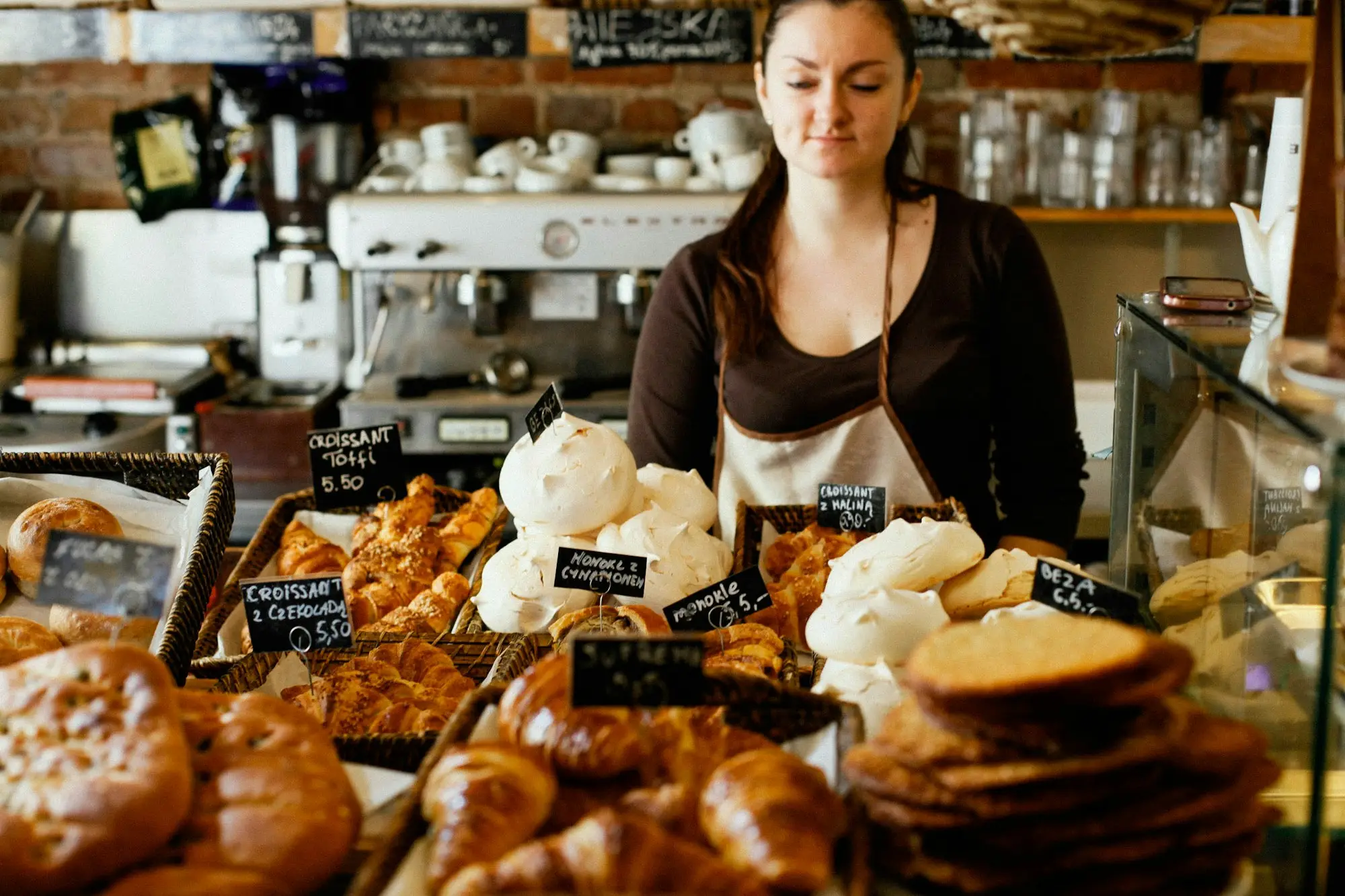 Bakery owner behind a counter of fresh bread and pastries